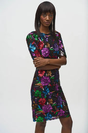 Exquisite sequined mesh sheath dress adorned with floral motifs, featuring a boat neck, V-neck back, and chic short sleeves with pads.